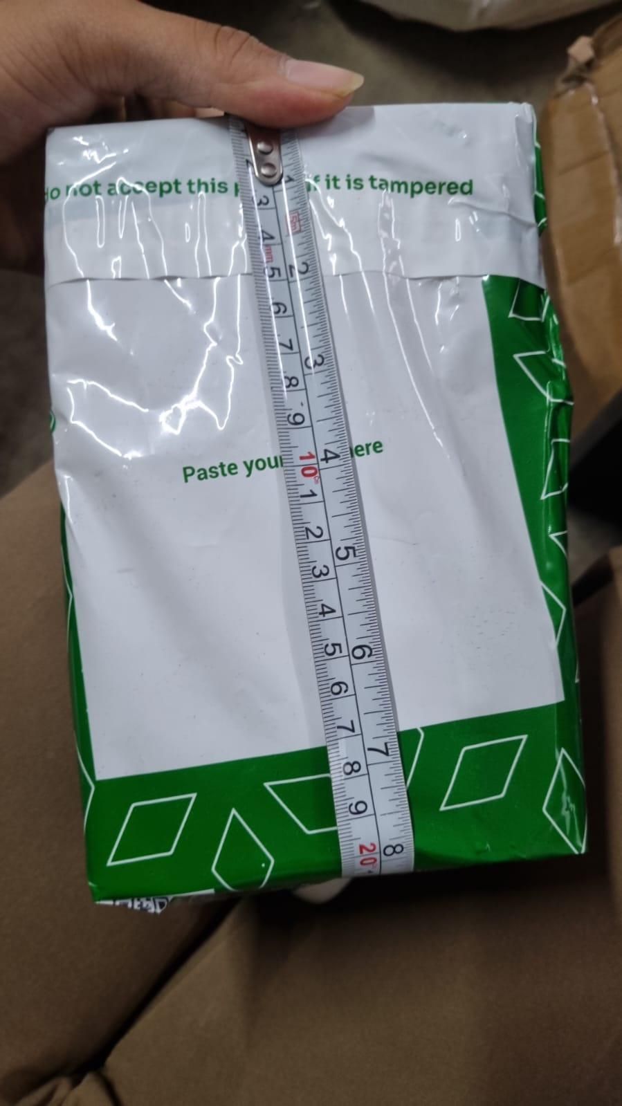 Ganesh Crystal LED Lamp - Shoppingstore25Shoppingstore258121759318A hand holds a green and white package with geometric designs and printed text, measuring about 20 centimeters—ideal for gifting items such as the Ganesh Crystal LED Lamp.